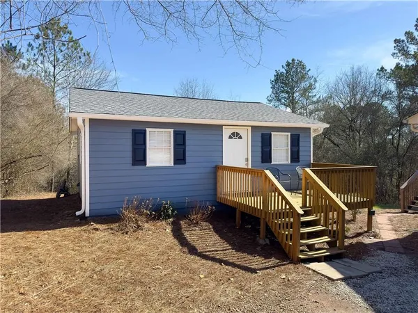 a view of a house with a small yard and wooden fence