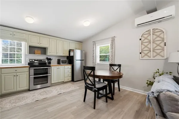 a kitchen with a table chairs refrigerator and a stove top oven