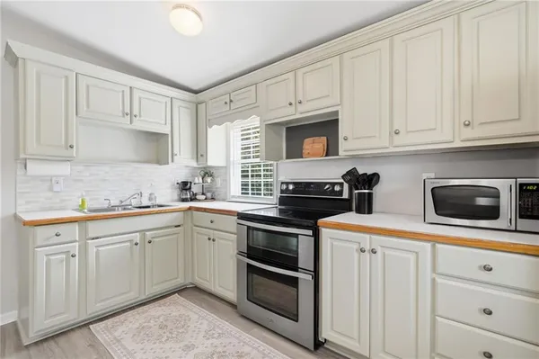 a kitchen with white cabinets and stainless steel appliances