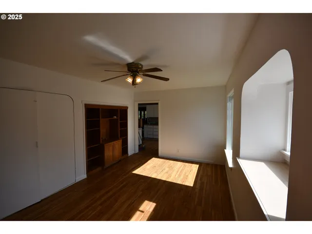 a view of an empty room with wooden floor