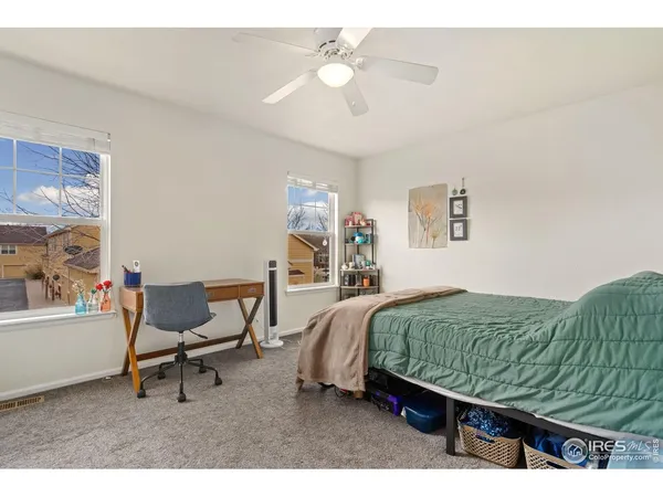 a bedroom with a bed a chair and a chandelier