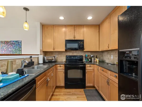 a kitchen with granite countertop a stove top oven sink and cabinets