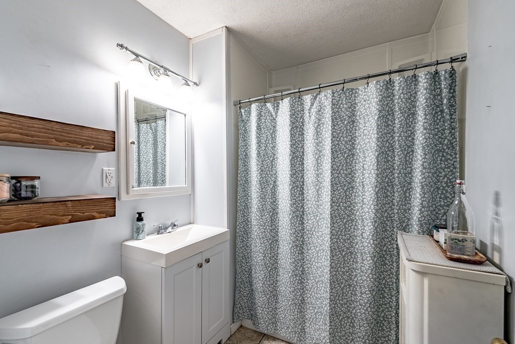 24 Manchester Terrace Springfield, MA 01108 - Photo 29 of 38 a bathroom with a sink a toilet and a mirror