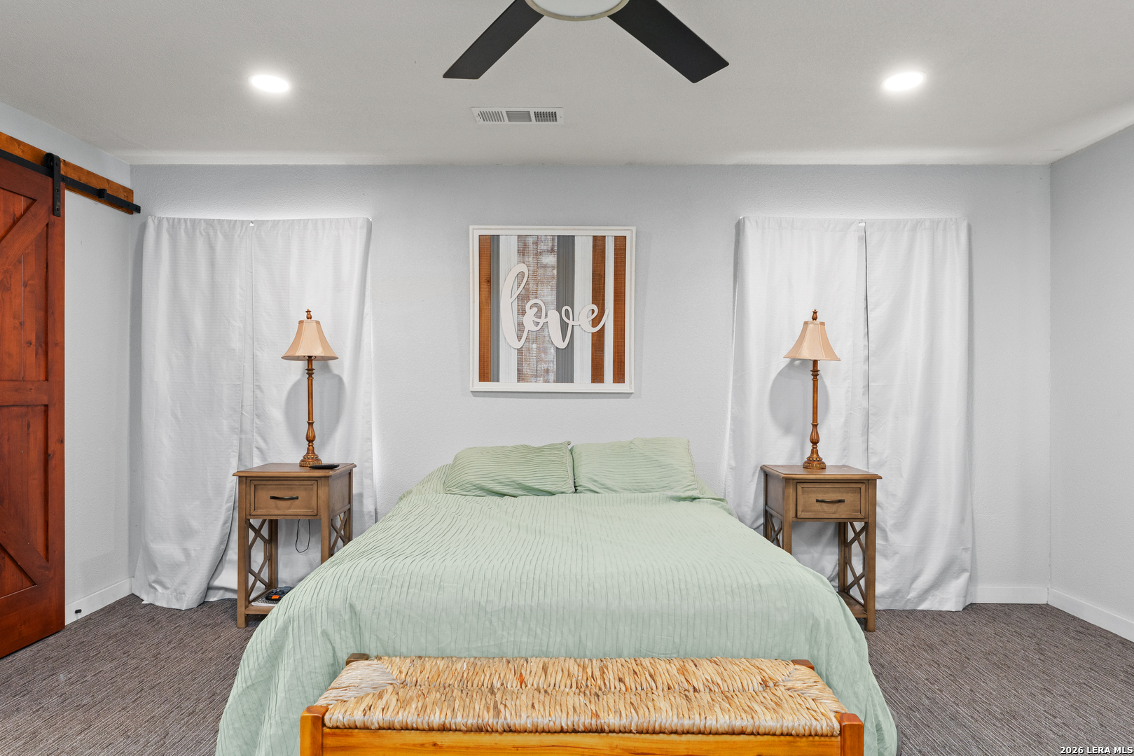 15285 South Skaggs Road Atascosa, TX 78002 - Photo 20 of 36 a bedroom with a bed and a chandelier