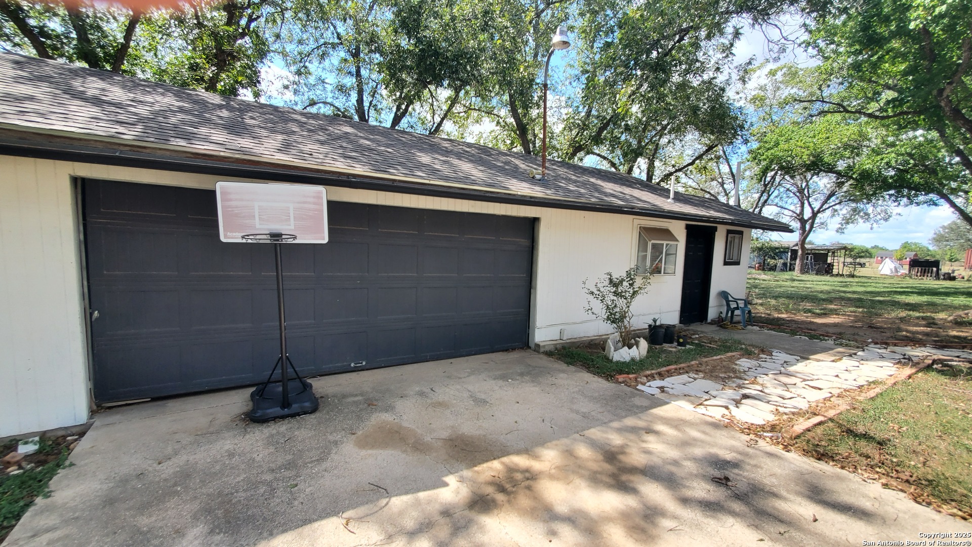 15285 South Skaggs Road Atascosa, TX 78002 - Photo 32 of 36 a backyard of a house with garage and table