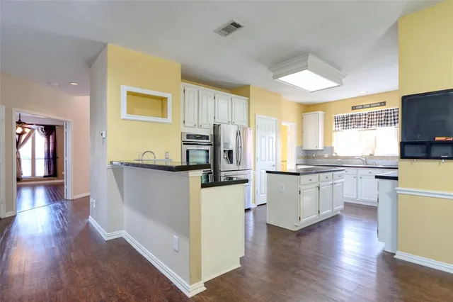 a kitchen with refrigerator cabinets and wooden floor