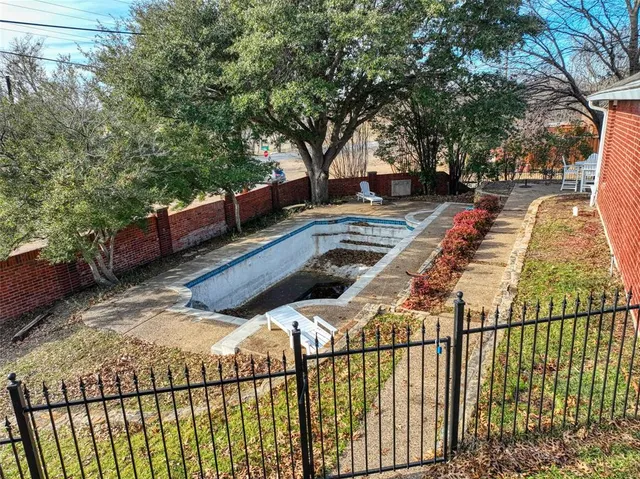 a view of a yard with wooden fence