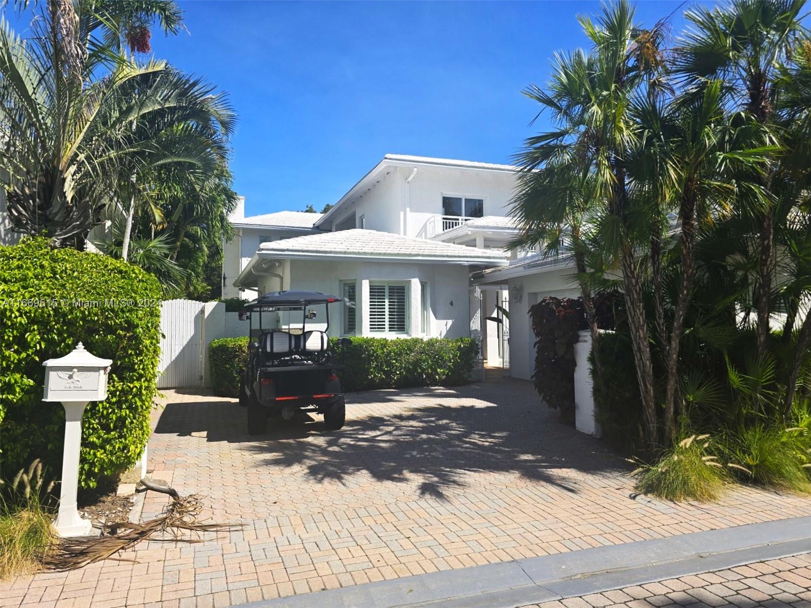 4 Turtle Walk, Unit 4 Key Biscayne, FL 33149 - Photo 1 of 29 a front view of a house with a yard