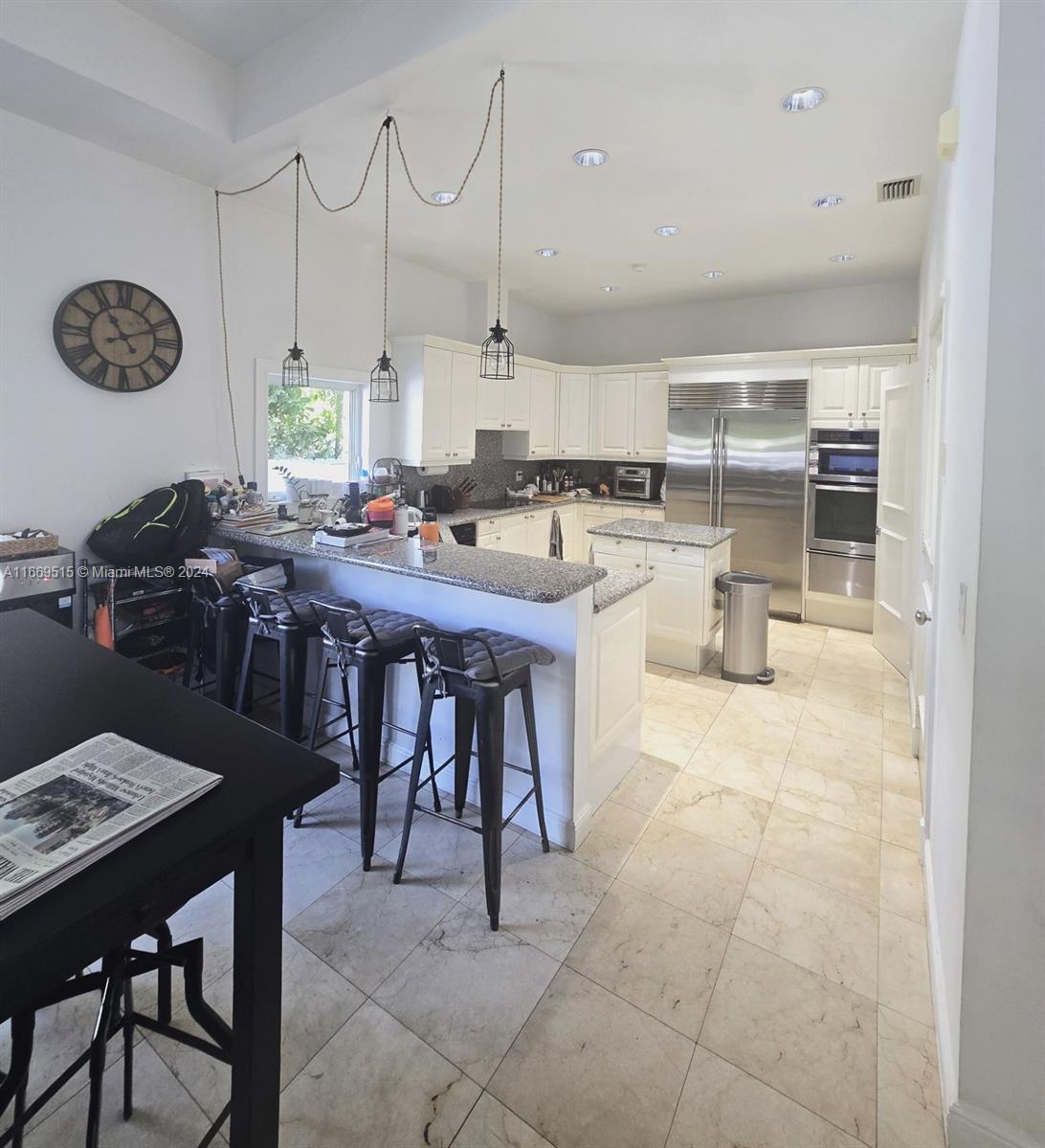 4 Turtle Walk, Unit 4 Key Biscayne, FL 33149 - Photo 14 of 29 a kitchen with a table chairs and a stove