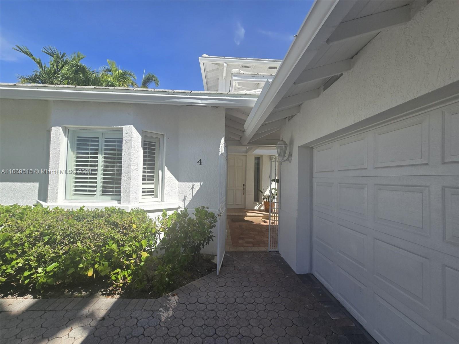 4 Turtle Walk, Unit 4 Key Biscayne, FL 33149 - Photo 2 of 29 front view of a house with a yard