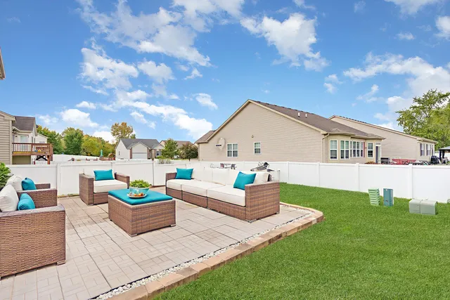 a backyard of a house with table and sofas