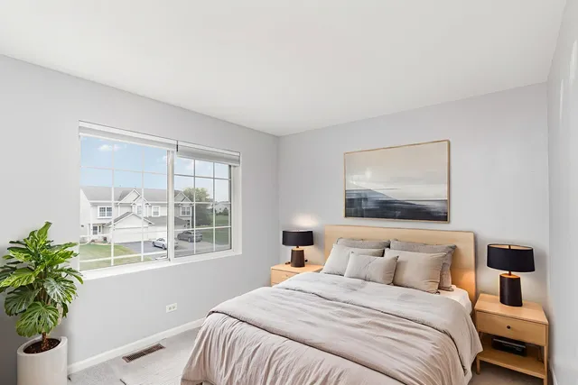 a bedroom with a bed and a large window