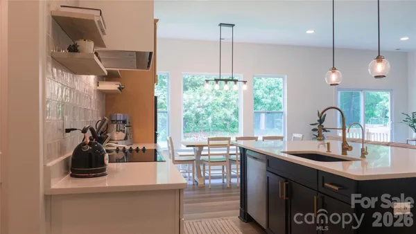 a kitchen with a sink a window and chairs
