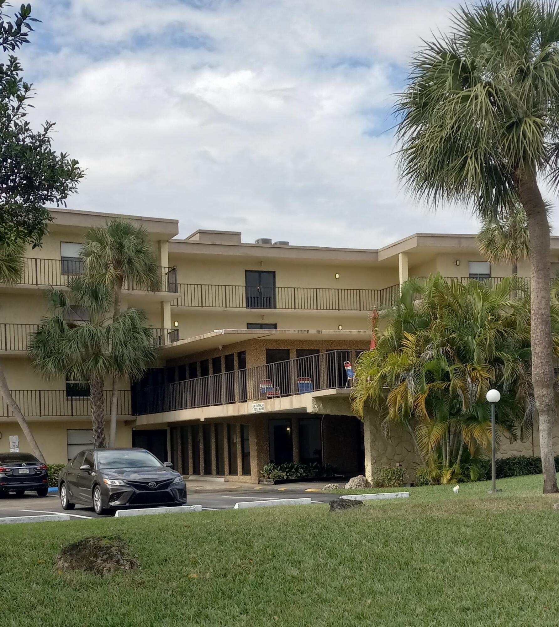9355 Southwest 8th Street, Unit 402 Boca Raton, FL 33428 - Photo 2 of 5 a front view of residential houses with yard and green space