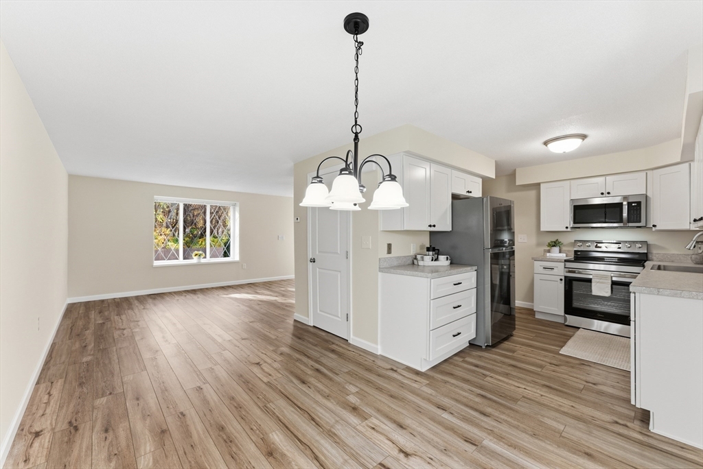 84 Fuller Street, Unit 1 Ludlow, MA 01056 - Photo 11 of 34 a kitchen with stove cabinets and wooden floor