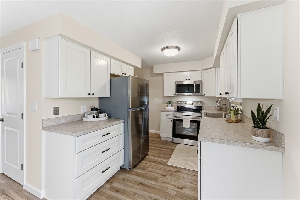 84 Fuller Street, Unit 1 Ludlow, MA 01056 - Photo 2 of 34 a kitchen with stainless steel appliances kitchen island granite countertop a stove refrigerator and a sink