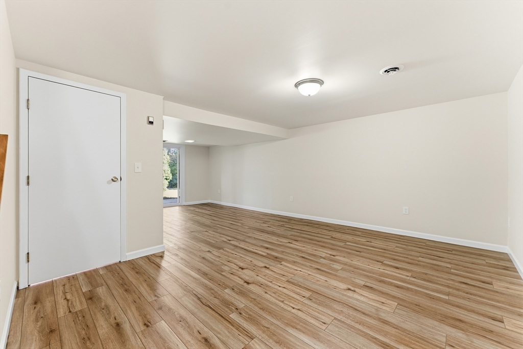 84 Fuller Street, Unit 1 Ludlow, MA 01056 - Photo 26 of 34 a view of an empty room with wooden floor and a bathroom