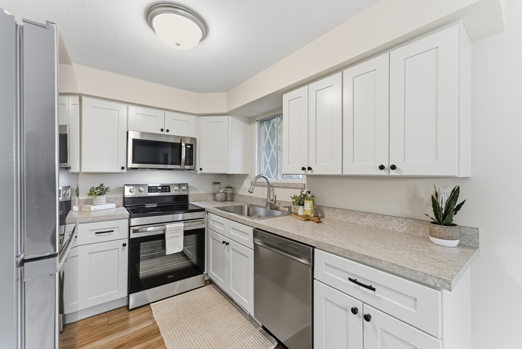 84 Fuller Street, Unit 1 Ludlow, MA 01056 - Photo 8 of 34 a kitchen with granite countertop white cabinets stainless steel appliances and a sink
