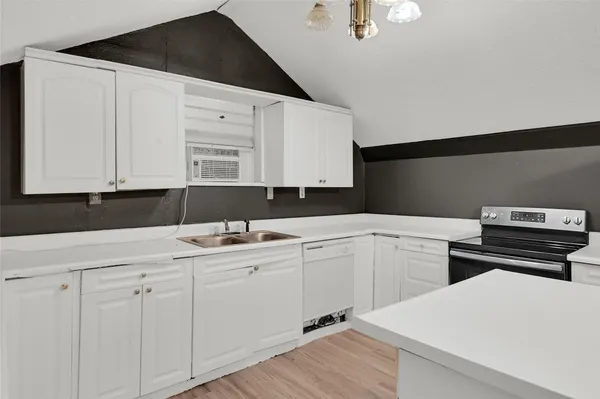 a kitchen with a sink dishwasher and white cabinets