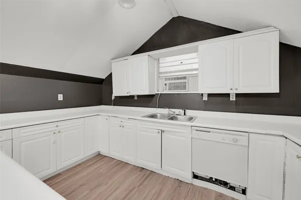 a kitchen with granite countertop white cabinets and sink
