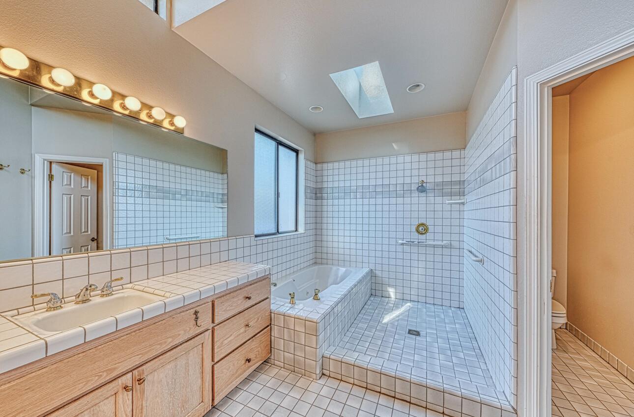 1056 Rodeo Road Pebble Beach, CA 93953 - Photo 13 of 17 a bathroom with a sink a granite counter and a glass door shower