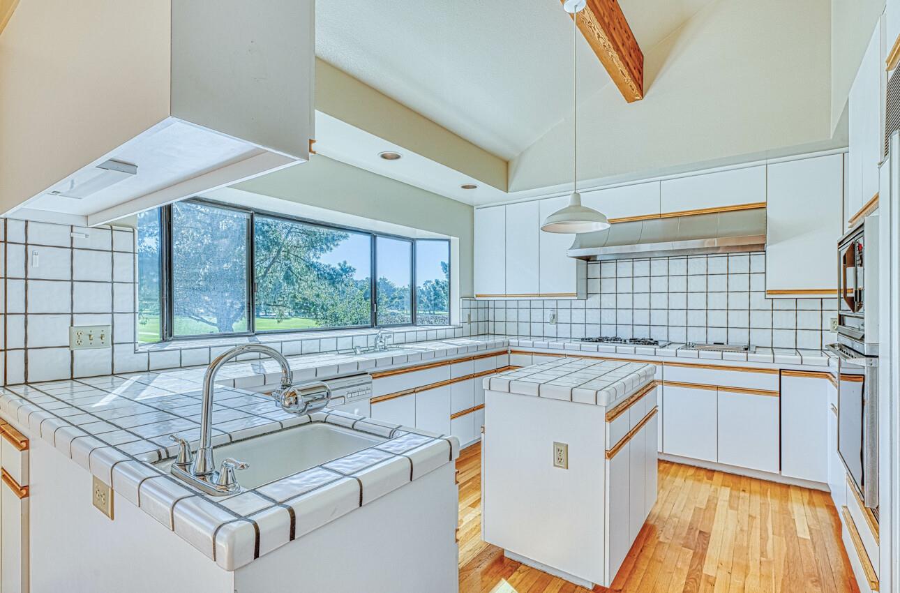 1056 Rodeo Road Pebble Beach, CA 93953 - Photo 7 of 17 a kitchen with a sink stove and cabinets