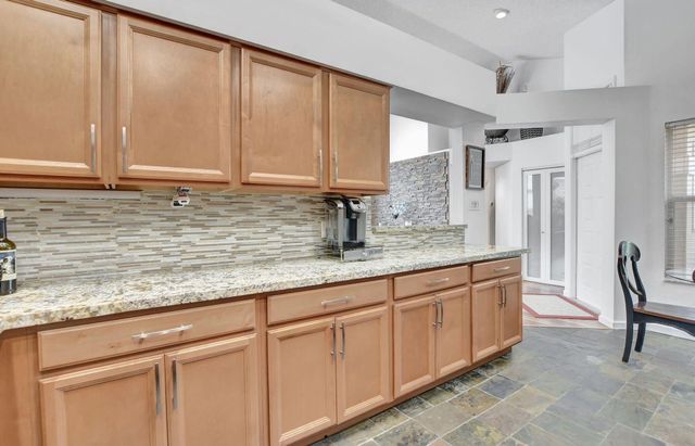 a kitchen with granite countertop a sink and a wooden cabinets