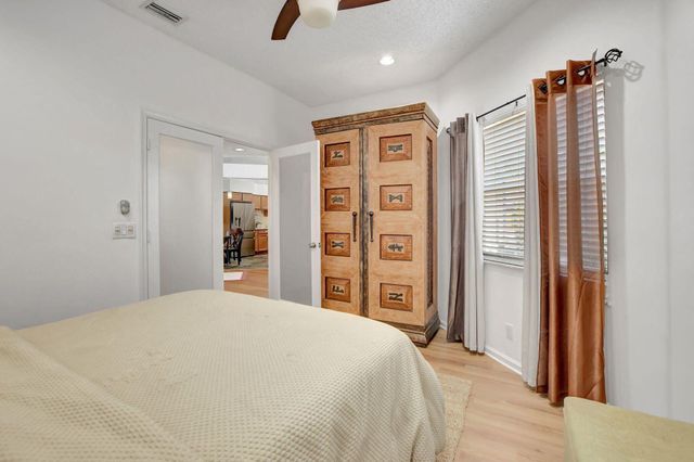 a bedroom with a large bed and a chandelier