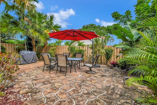 a view of a patio with table and chairs under an umbrella