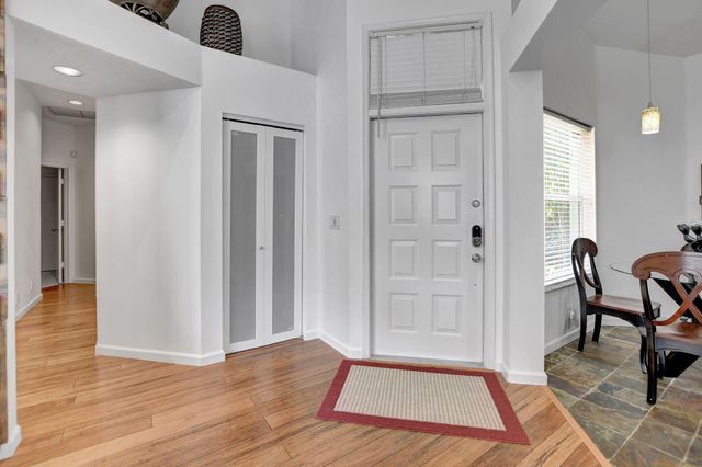an entryway space with wooden floor and windows