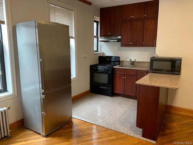 43-33 48th Street, Unit 4A Queens, NY 11104 - Photo 7 of 14 a kitchen with stainless steel appliances granite countertop a refrigerator and a stove top oven
