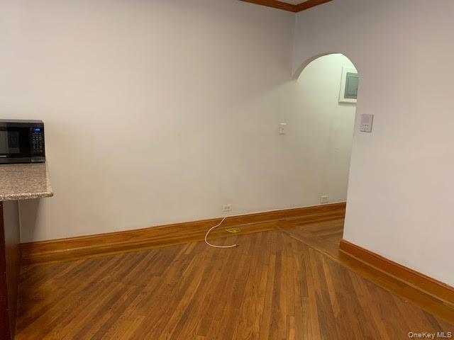43-33 48th Street, Unit 4A Queens, NY 11104 - Photo 9 of 14 a view of empty room with wooden floor and fan