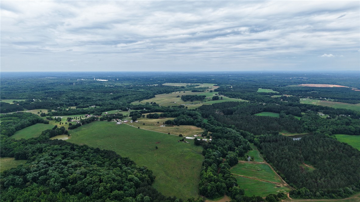 2125 Highway 247 Belton, SC 29627 - Photo 5 of 15 Vast green pastures and dense woodlands stretch across this expansive rural landscape, inviting exploration.