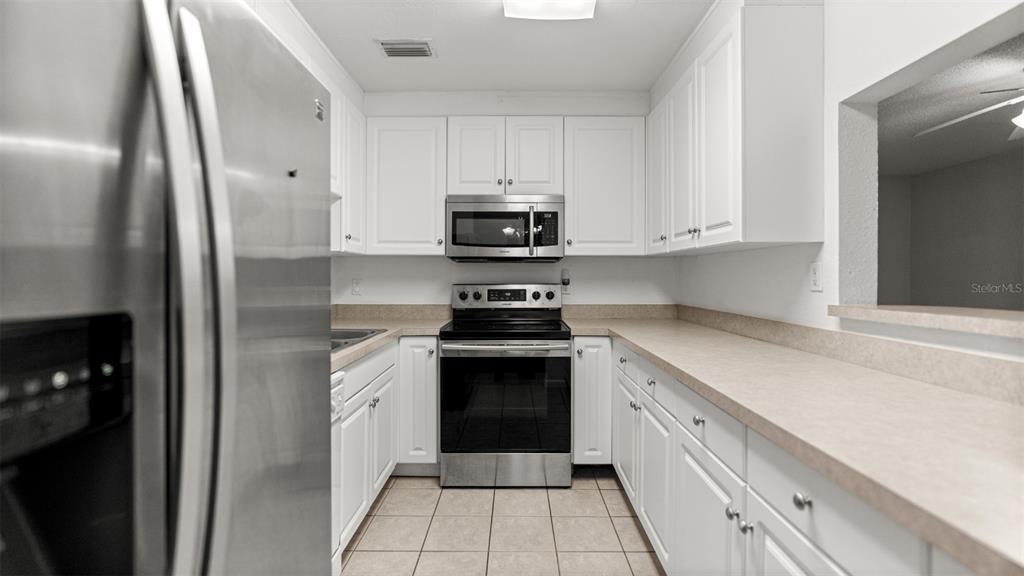 501 Southwest 75th Street, Unit B5 Gainesville, FL 32607 - Photo 9 of 38 a kitchen with white cabinets and black appliances