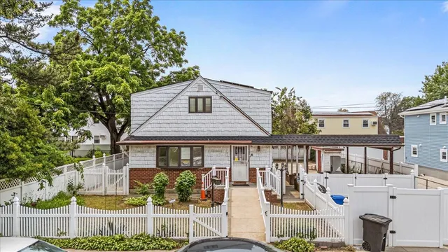 a front view of a house with a garden and plants