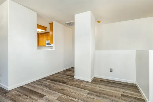 a view of a room with wooden floor and a bathroom