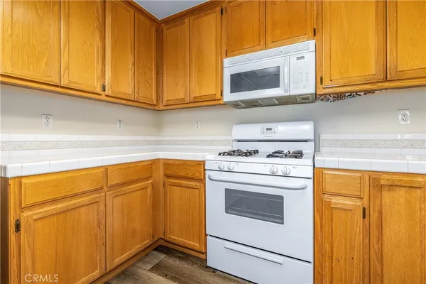 a kitchen with stainless steel appliances granite countertop a sink cabinets and a wooden floor
