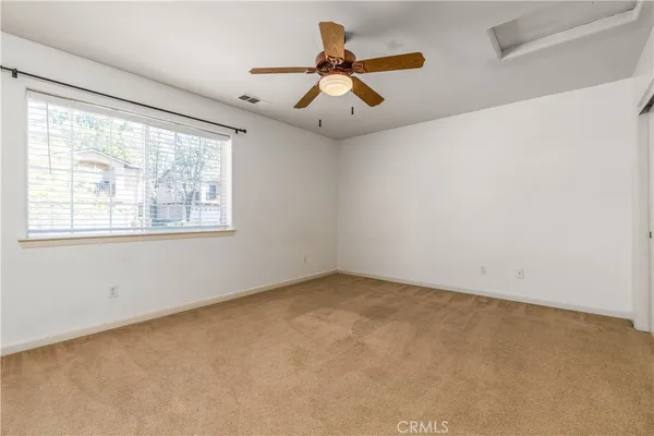 an empty room with a window and a fan