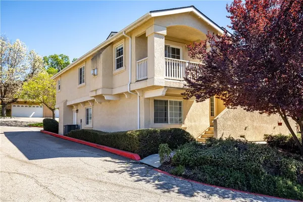 a front view of a house with a yard and trees