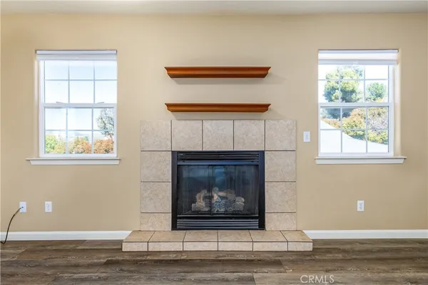 a view of an empty room with window and fire place