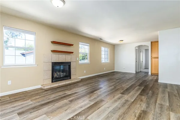 a view of an empty room and window and wooden floor