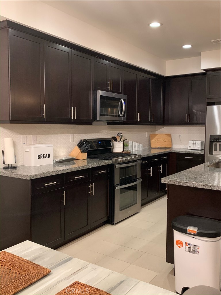 2017 Tango Loop, Unit 1 Chula Vista, CA 91915 - Photo 22 of 32 a kitchen with stainless steel appliances granite countertop a stove a sink and a microwave