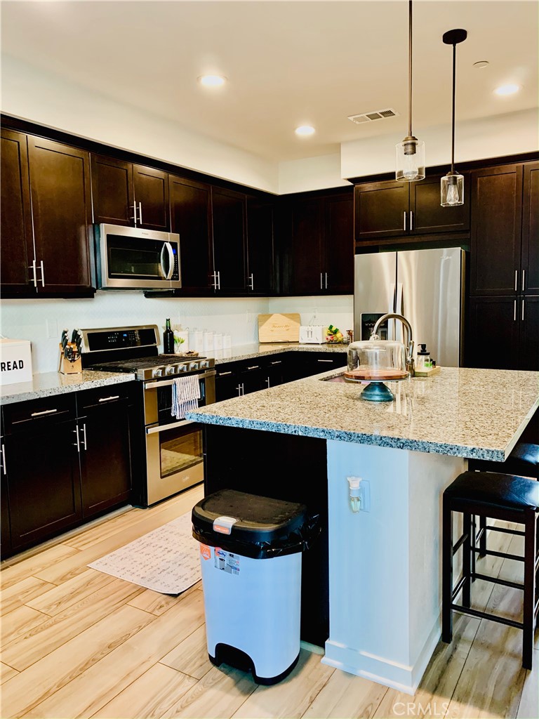 2017 Tango Loop, Unit 1 Chula Vista, CA 91915 - Photo 3 of 32 a kitchen with a sink and a stove top oven with wooden floor