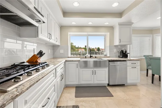 a kitchen with white cabinets and appliances