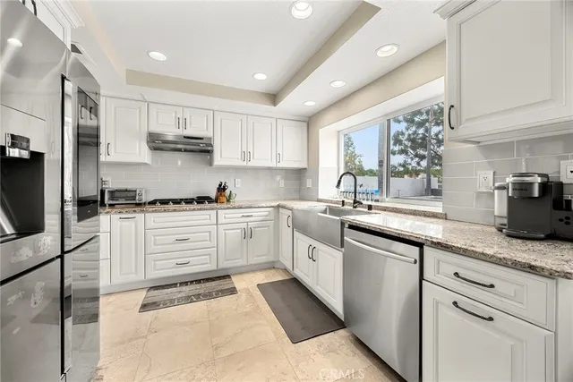 a kitchen with granite countertop white cabinets and white appliances