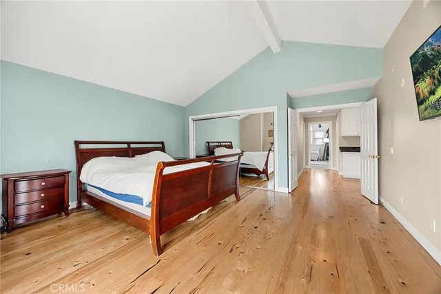 a spacious bedroom with a bed and a flat screen tv