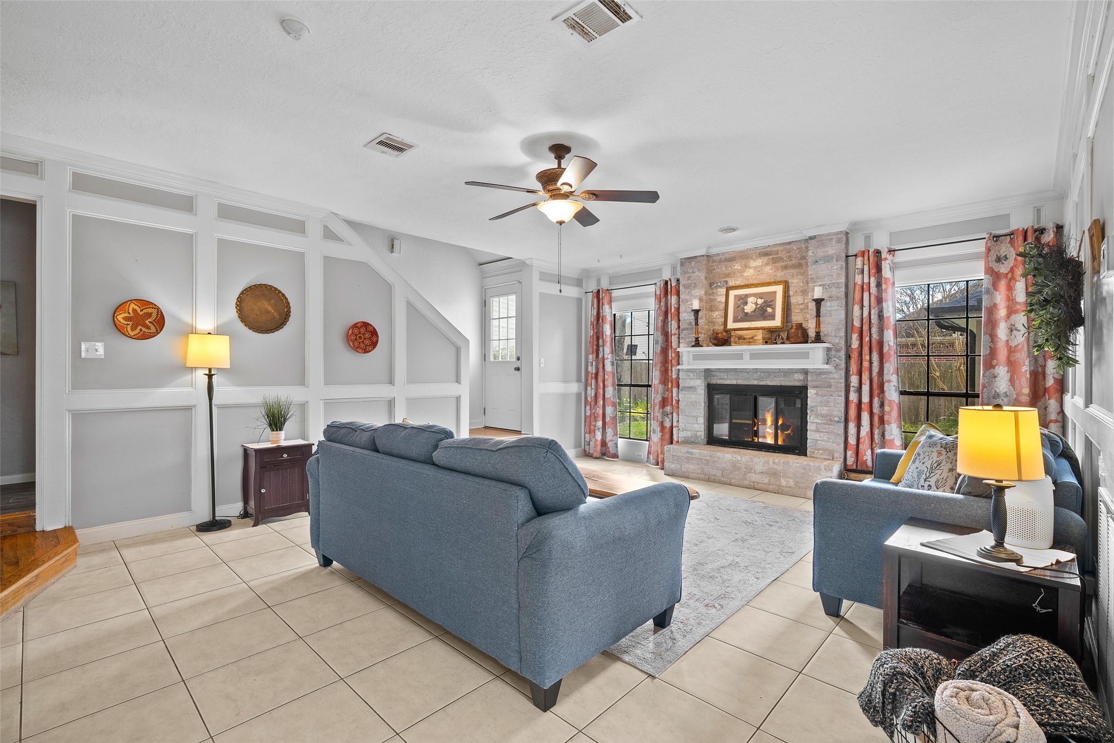 41 Windsor Drive Conroe, TX 77304 - Photo 9 of 39 From this angle, the living room highlights the brick fireplace as a central focal point, framed by large windows that bring in natural light. A welcoming space designed for relaxing evenings and gatherings.