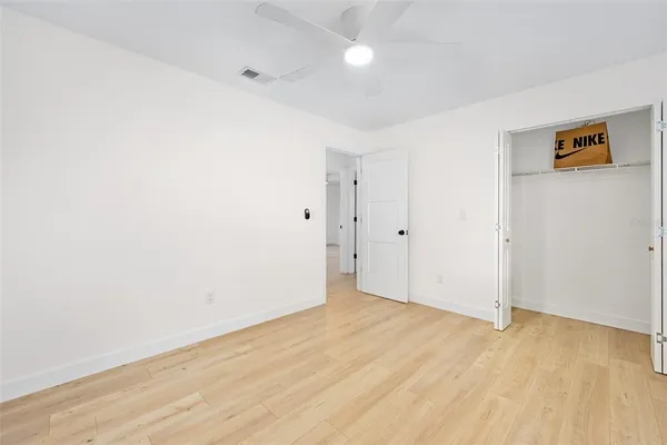 an empty room with fan and windows