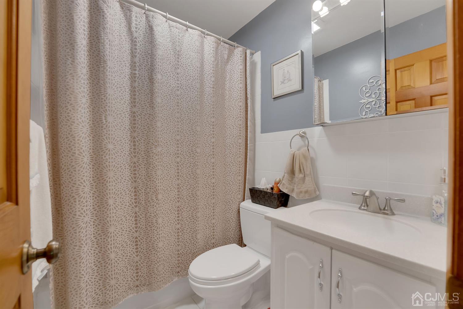 30 Savage Road Kendall Park, NJ 08824 - Photo 15 of 20 a bathroom with a sink a toilet and shower curtain