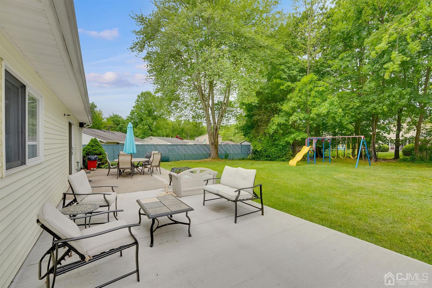 30 Savage Road Kendall Park, NJ 08824 - Photo 18 of 20 a view of backyard with table and chairs and a large tree